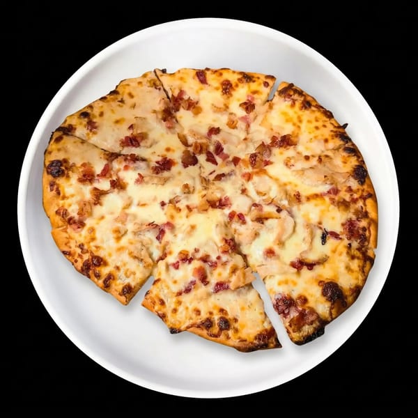 Round flatbread pizza with melted cheese, chicken, and bacon bits, sliced on a white plate.