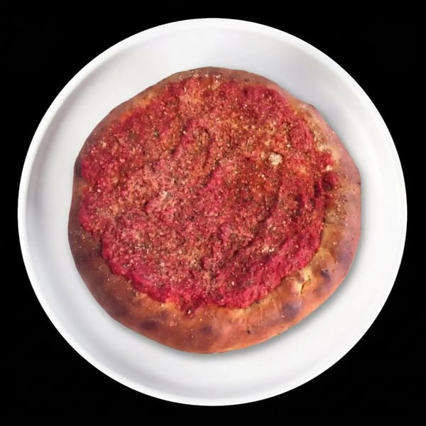 Round pizza with red sauce and seasoning on a white plate.